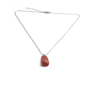 Detail of a polished red-brown stone pendant on a silver-colored metallic chain