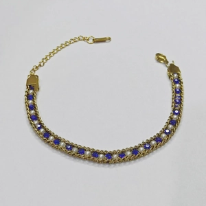Macro shot of gold plated chain bracelet with blue sapphires and white pearls