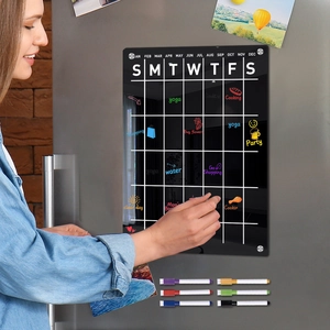 Detail showing hand writing on a magnetic acrylic weekly calendar board for refrigerators