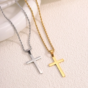 Dettaglio dei ciondoli a croce in oro e argento con catene a corda in acciaio