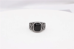 Macro shot of vintage steel ring with square black gemstone and Celtic knot carvings