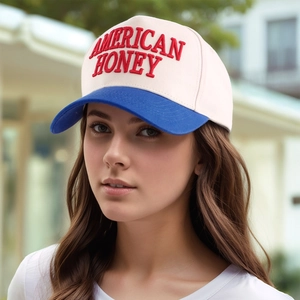 Macro shot of 3D 'AMERICAN HONEY' embroidery on a blue and white baseball cap
