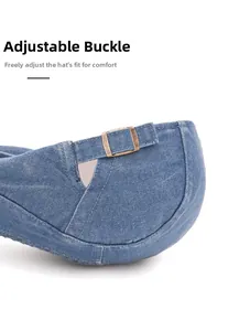 Close-up of adjustable metal buckle on blue washed denim newsboy cap back
