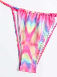 Detail van kleurrijk tie-dye bikinibroekje met zijstrikjes en elastische badstof