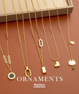 Close-up of five gold titanium necklaces featuring heart and geometric pendants on leather