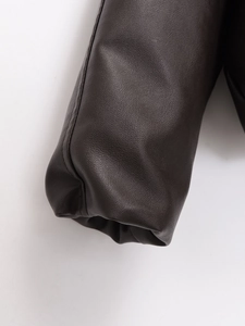 Detailed close-up showing texture and stitching of dark brown faux leather jacket cuffs