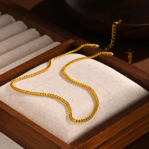 Macro shot of 14K gold-plated stainless steel curb chain on a premium wooden display box