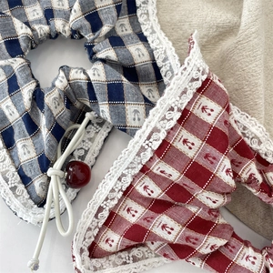Detail of checkered scrunchies with white lace edges and red cherry pendants