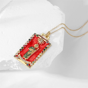 Detail of gold rectangular tarot pendant with red enamel and colorful gemstone inlay