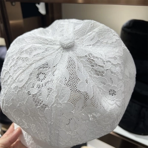 Close-up of the intricate white floral lace texture and breathable mesh on the summer hat