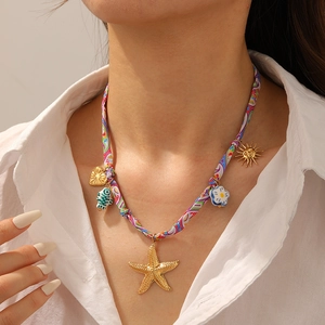 Détail du collier en corde de tissu coloré avec pendentifs étoile de mer et soleil