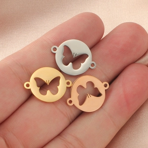 Macro view of butterfly connectors in silver, gold, and rose gold on silk fabric