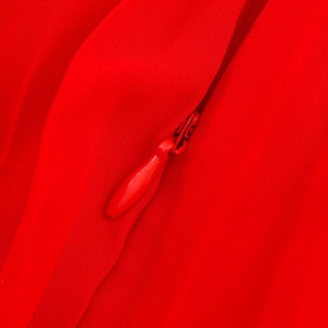 Détail d'une fermeture éclair rouge et d'un tissu de robe plissée à texture lisse