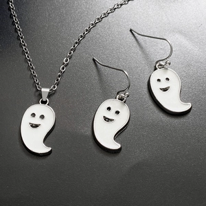 Close-up of silver necklace and earrings set with white cartoon ghost enamel charms