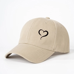 Beige cotton baseball cap with black heart embroidery and adjustable curved brim