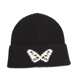 Detailed close-up of butterfly jacquard pattern on a black cuffed knit beanie hat