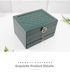 Detail view of double-layer dark green leather jewelry box with quilted pattern and gold lock