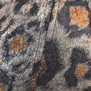 Macro shot of gold foil leopard print jacquard fabric with detailed stitching