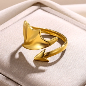 Detailed close-up of golden open ring with unique devil wing and arrow design on silk