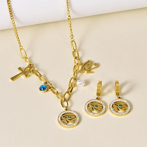 Gold Eye of Horus and Ankh necklace with matching earrings jewelry set on a beige background