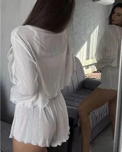 Detailed mirror view of white three-piece loungewear with vertical stripe texture and ruffled hems
