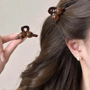 Detail of a brown leopard print mini claw clip showing handheld view and hairstyle wear