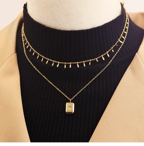 Dettaglio di una collana a doppio strato in titanio placcato oro 18K con pendente a stella