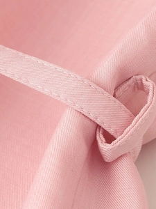 Vista macro della trama del tessuto twill rosa e cuciture dettagliate sulla cintura