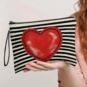 Striped cosmetic bag with large red heart and wristlet strap for portable travel makeup storage
