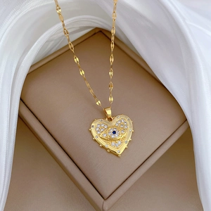 Luxurious gold heart necklace with evil eye pendant and crystals on a jewelry box