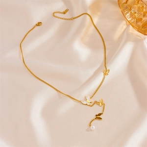 Detail of golden butterfly pendant with white shell and pearl on silk background