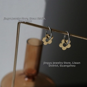 Close-up of daisy floral dangle earrings in mixed silver and gold stainless steel