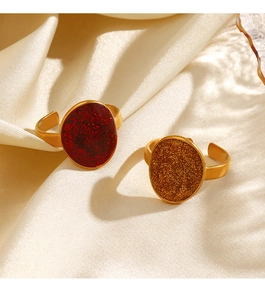 Detail of gold-plated adjustable ring with oval shimmering red and gold enamel inlay