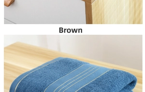 Detail showing folded blue cotton bath towel with yellow stripes on a wooden surface