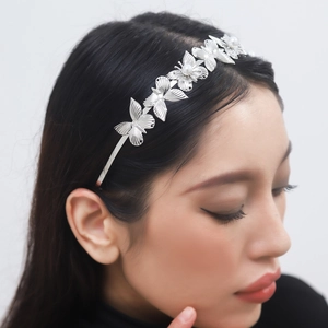 Detail of silver baroque butterfly headband with white pearls on a professional model