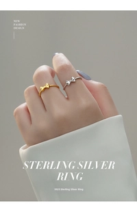 Detailed view of S925 sterling silver bow rings in gold and silver on a model's hand