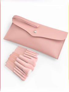 Detailed view of 10-piece peach pink makeup brush set with matching leather storage pouch