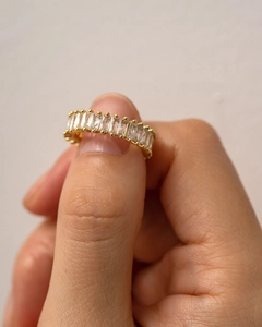 Macro detail of 18k gold plated ring with baguette-cut zircon stones and bead edging
