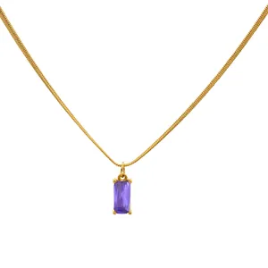 Macro shot of gold snake chain with a rectangular purple zircon pendant and metal texture