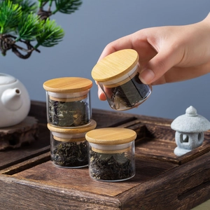 Portable mini glass tea canisters with bamboo lids set of 4 on a wooden tray