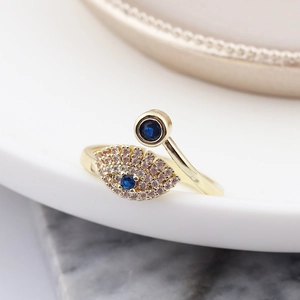 Detailed close-up of evil eye snake ring in gold finish with blue and white crystals