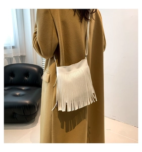 Detailed back view of a white tassel crossbody bag styled with a minimalist outfit