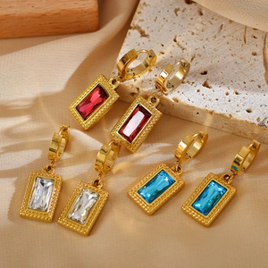 Detailed shot of retro gold rectangle earrings with red, white, and blue zircon gems