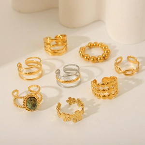 Detail of diverse adjustable metal rings with floral, bead, and wavy textured patterns