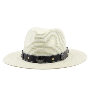 Detail of cream straw Panama hat featuring bohemian leather band with metallic floral studs
