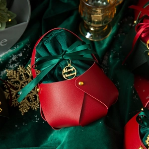 Premium Christmas gift bag featuring red faux leather and green velvet drawstring pouch