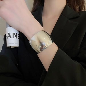 Detail shot of wide silver knotted cuff bracelet with a polished mirror finish on model