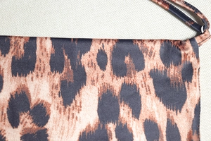Close-up of leopard print fabric showing fine knit texture and stitching details