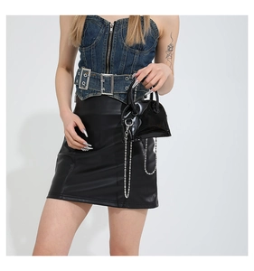 Détail d'un mini sac à main en cuir verni noir avec chaîne argentée et poignée
