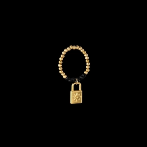 Detailed shot of elastic bead ring with a sunburst engraved golden padlock pendant
